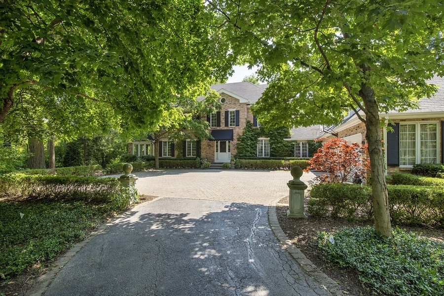 a front view of a house with a yard and tree