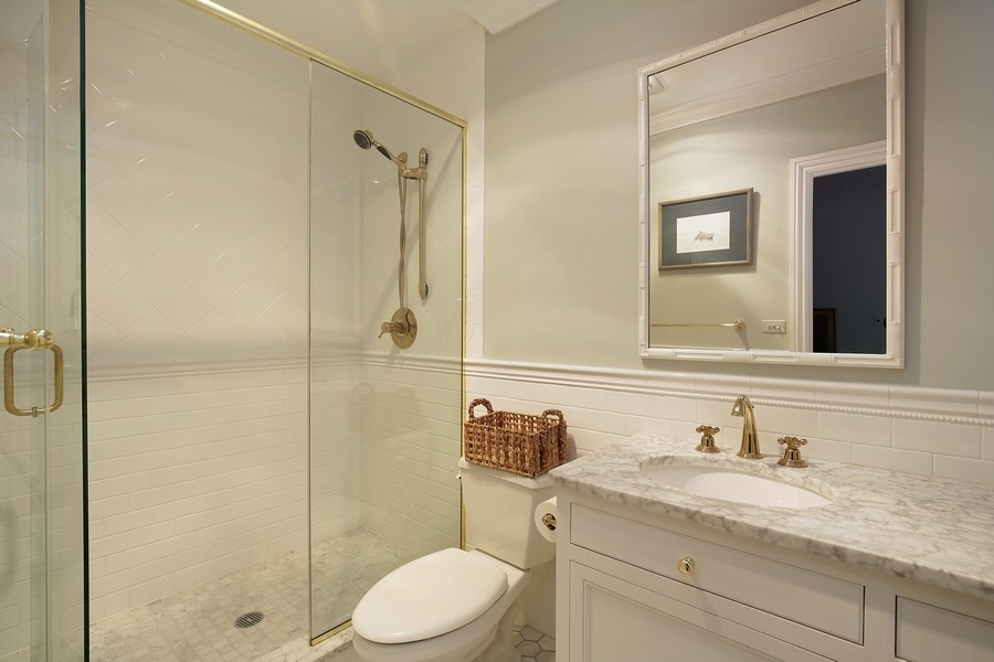 641 Briar Lane Northfield, IL 60093 - Photo 24 of 35 a bathroom with a granite countertop sink toilet mirror and shower