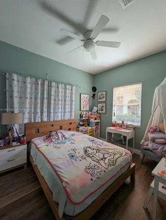 a bedroom with a bed closet and a flat tv screen on a dresser