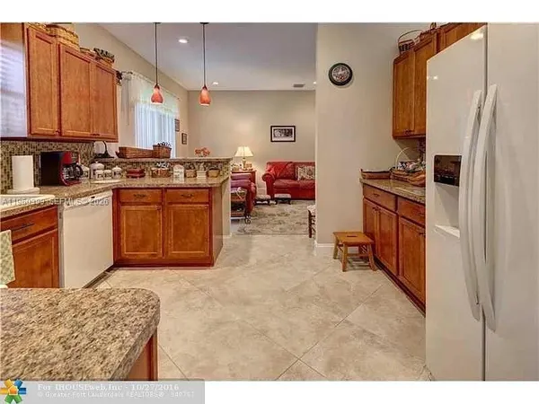a kitchen with stainless steel appliances granite countertop a sink and a refrigerator