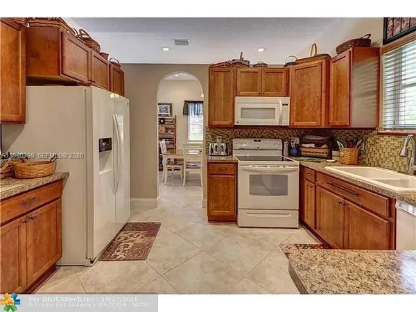 a kitchen with stainless steel appliances granite countertop a sink a stove and a refrigerator