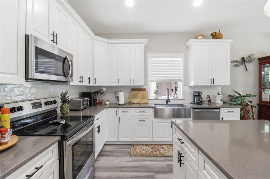 9689 East White Egret Path Inverness, FL 34450 - Photo 12 of 44 a kitchen with stainless steel appliances granite countertop a stove a sink and a microwave