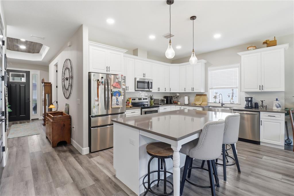 9689 East White Egret Path Inverness, FL 34450 - Photo 10 of 44 a large kitchen with cabinets chairs and stainless steel appliances