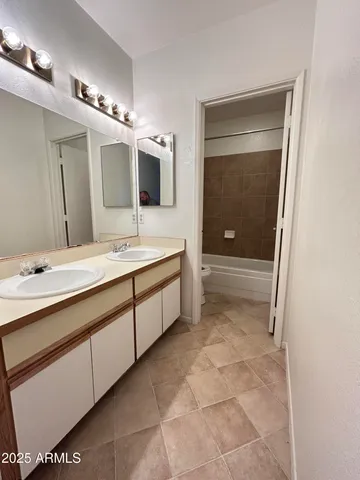 a spacious bathroom with a double vanity sink a mirror and a