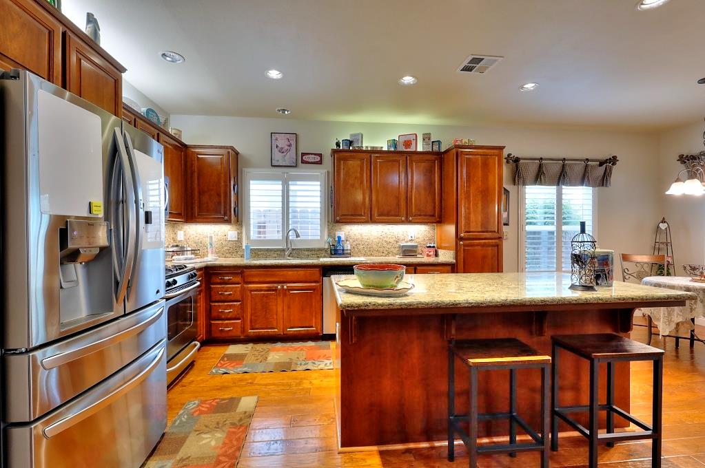 4152 Post Oak Drive Turlock, CA 95382 - Photo 28 of 71 a kitchen with stainless steel appliances granite countertop a sink and wooden cabinets