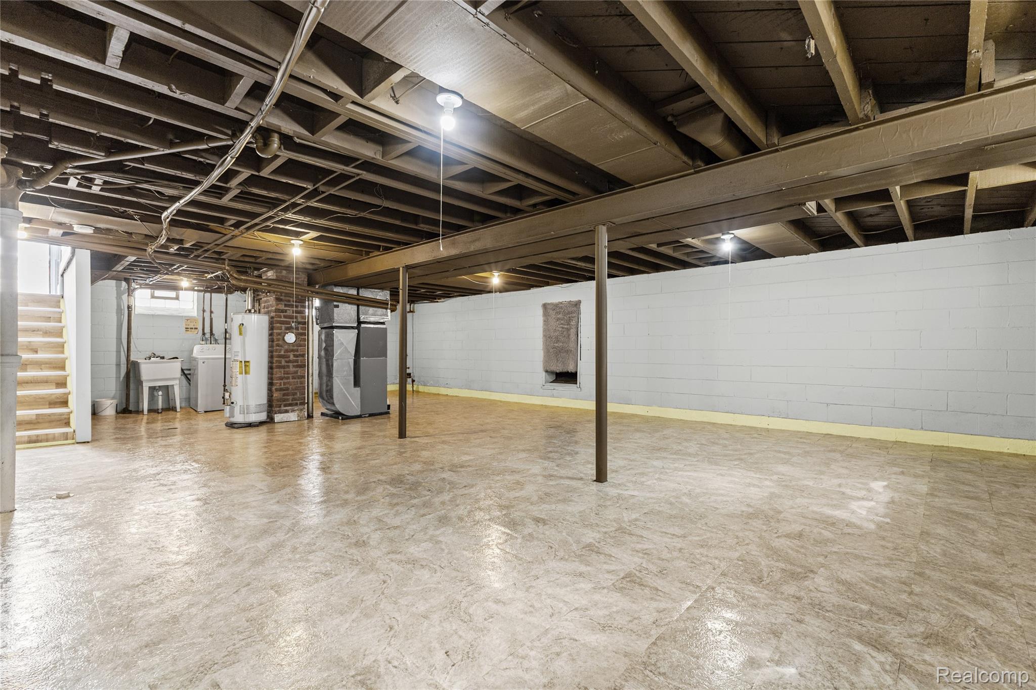 26508 Five Mile Road Redford, MI 48239 - Photo 30 of 41 Spacious basement area featuring a concrete block wall, exposed ceiling beams, and concrete flooring