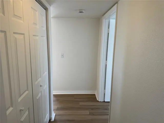 a view of a hallway with wooden floor