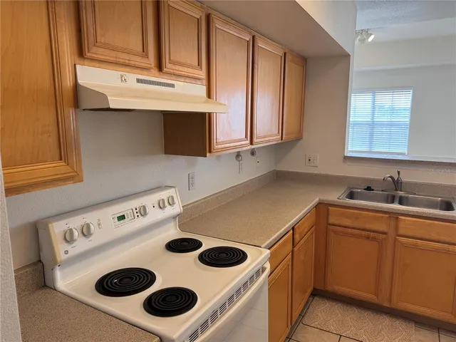 a kitchen with a sink a stove and cabinets