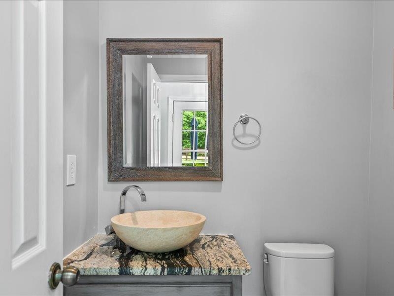 8104 Jack Bond Road Arlington, TN 38002 - Photo 13 of 40 a bathroom with a toilet a sink and mirror