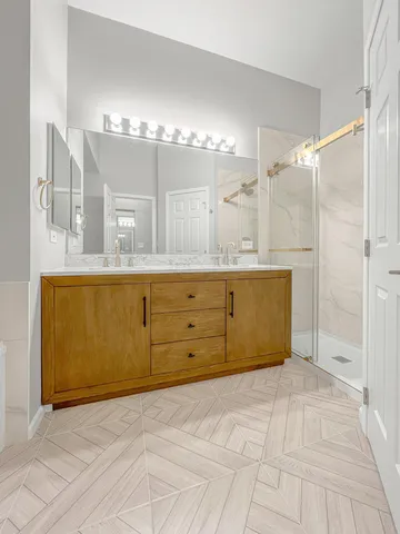a bathroom with a granite countertop sink a mirror and a shower