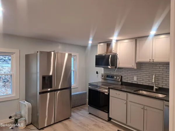 a kitchen with stainless steel appliances granite countertop a refrigerator and a sink