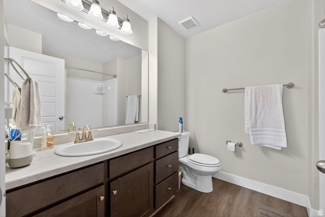 412 McClellan Court Provo, UT 84601 - Photo 17 of 20 Full bathroom with vanity, dark wood-style floors, and a shower