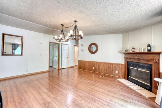 5359 Owltown Road Blairsville, GA 30512 - Photo 24 of 52 a view of a livingroom with a fireplace a chandelier and wooden floor