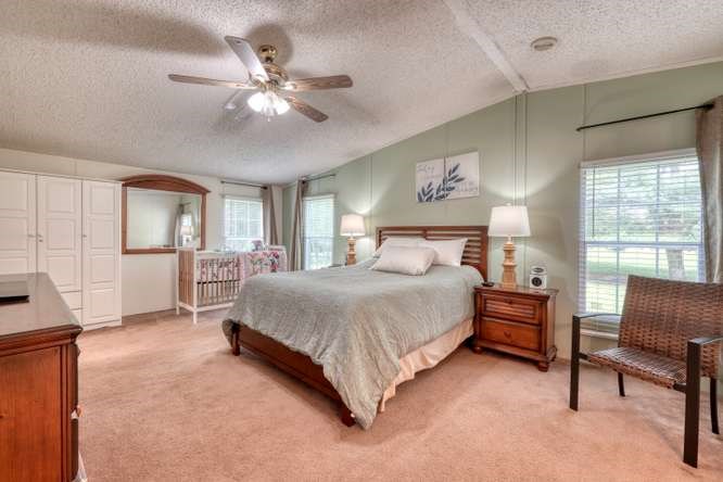 5359 Owltown Road Blairsville, GA 30512 - Photo 26 of 52 a bedroom with a large bed and a chandelier