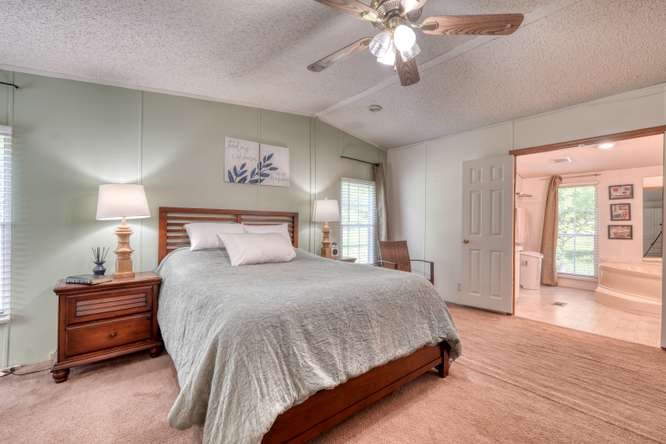 5359 Owltown Road Blairsville, GA 30512 - Photo 27 of 52 a bedroom with a bed and a chandelier