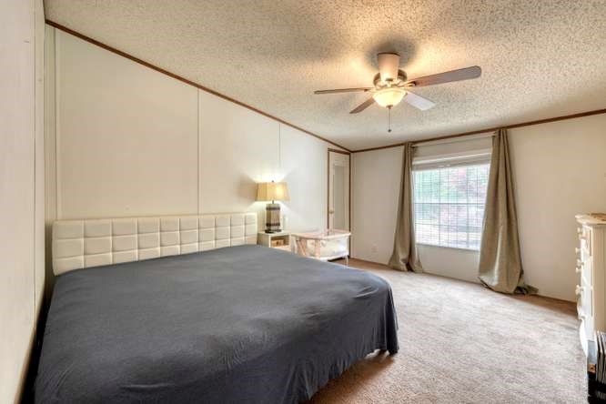 5359 Owltown Road Blairsville, GA 30512 - Photo 31 of 52 a spacious bedroom with a bed and a chandelier