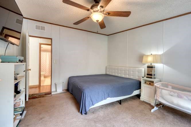 5359 Owltown Road Blairsville, GA 30512 - Photo 32 of 52 a bedroom with a bed and a chandelier