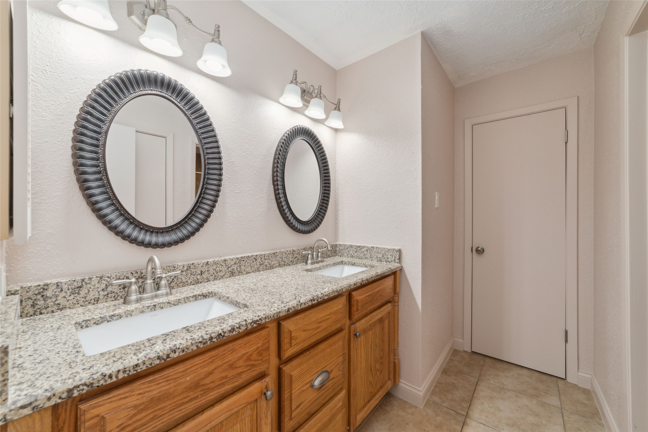 21603 Slippery Creek Lane Spring, TX 77388 - Photo 24 of 28 a bathroom with a granite countertop double vanity and a mirror
