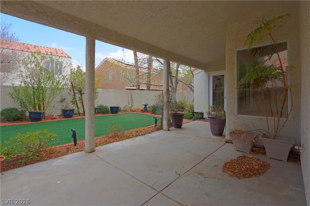 2108 Crestpoint Way Las Vegas, NV 89134 - Photo 22 of 27 A covered patio extends to a well-maintained yard, offering a tranquil outdoor retreat.