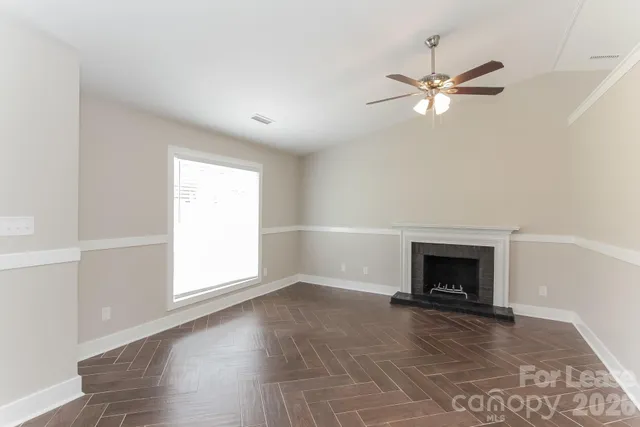 a view of empty room with fireplace and fan