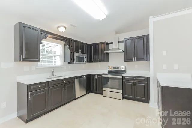 a kitchen with stainless steel appliances granite countertop a stove sink and cabinets