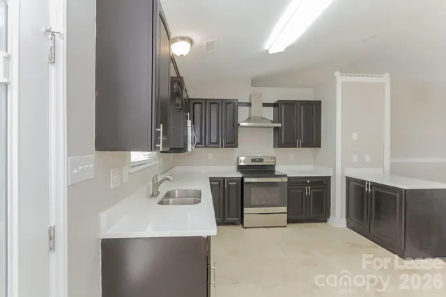 a kitchen with kitchen island granite countertop a sink stove and refrigerator