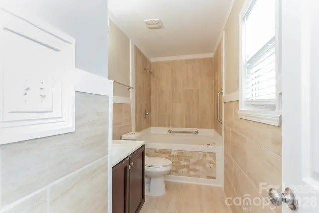 a bathroom with a granite countertop sink toilet and shower