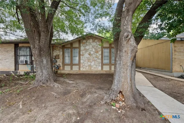 a view of a house with large trees and a tree