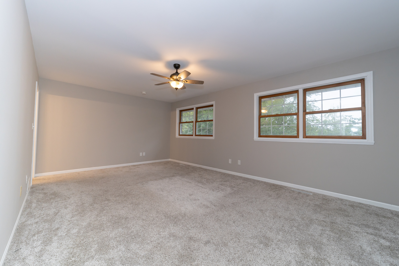 4818 5th Street Winthrop Harbor, IL 60096 - Photo 20 of 42 an empty room with windows and chandelier fan