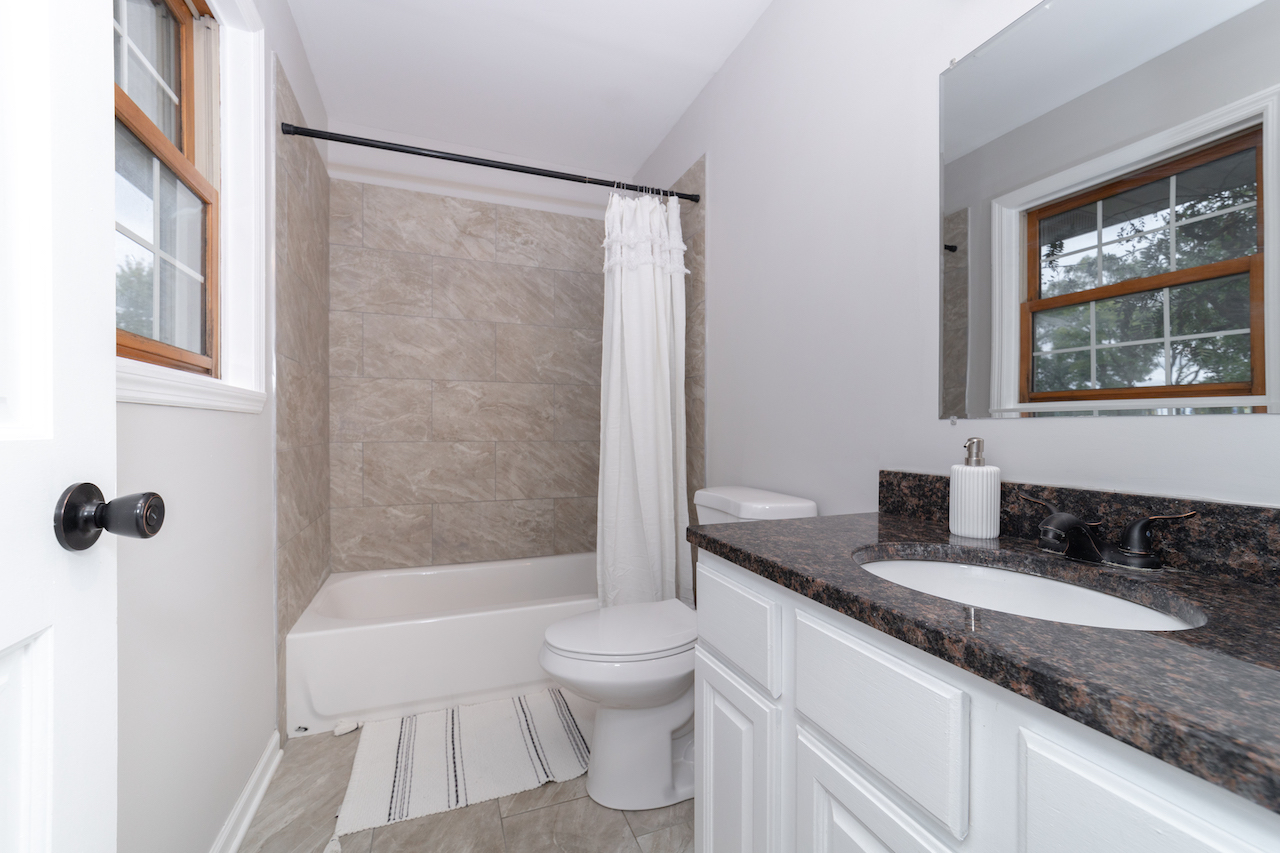 4818 5th Street Winthrop Harbor, IL 60096 - Photo 23 of 42 a bathroom with a granite countertop sink toilet and shower