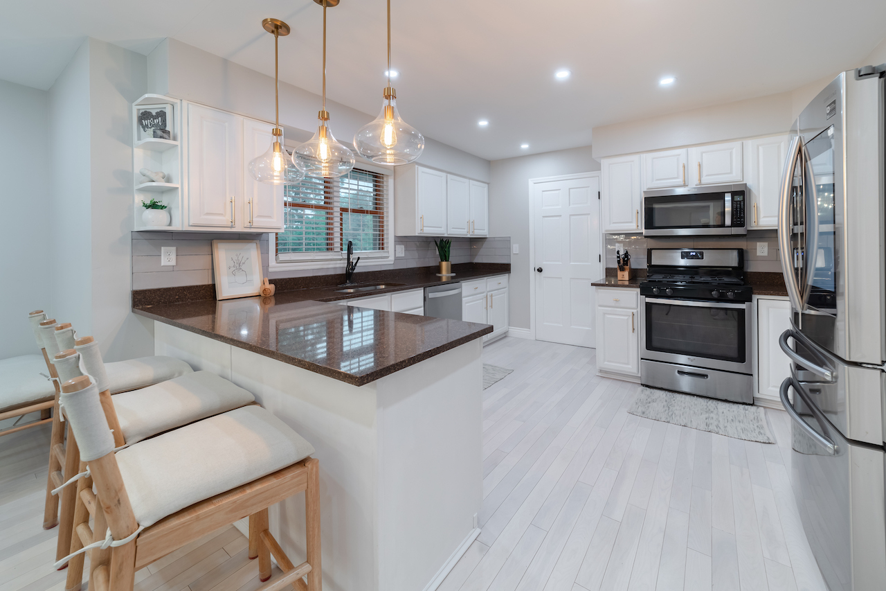 4818 5th Street Winthrop Harbor, IL 60096 - Photo 9 of 42 a kitchen with stainless steel appliances granite countertop a stove top oven a sink dishwasher a refrigerator and a dining table with wooden floor