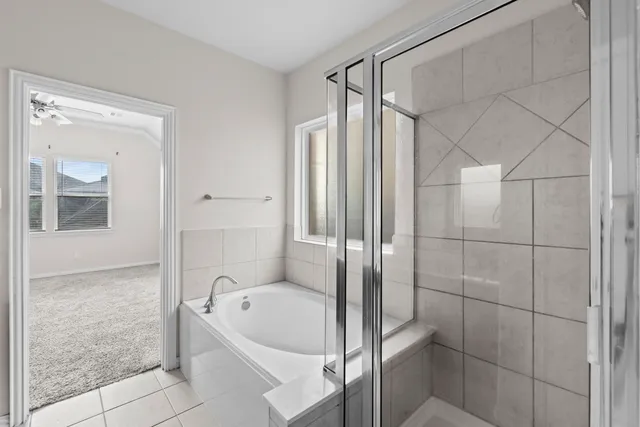 a bathroom with a tub shower and mirror