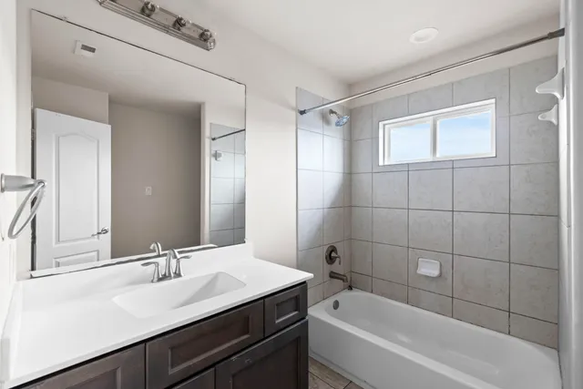 a bathroom with a bath tub sink mirror and shower