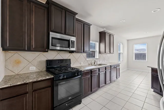 a view of a room with a chandelier and a ceiling fan