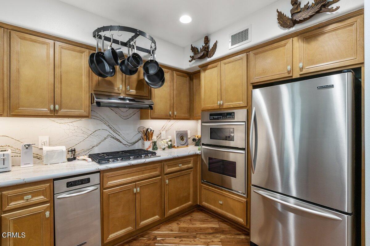 4322 Tradewinds Drive Oxnard, CA 93035 - Photo 11 of 30 a kitchen with stainless steel appliances granite countertop a sink a stove and refrigerator