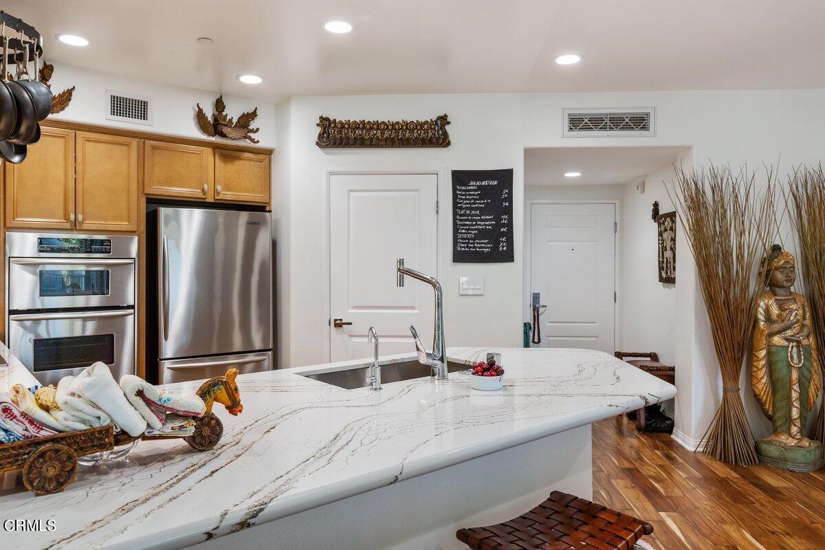 4322 Tradewinds Drive Oxnard, CA 93035 - Photo 12 of 30 a kitchen with stainless steel appliances kitchen island granite countertop a refrigerator and a sink