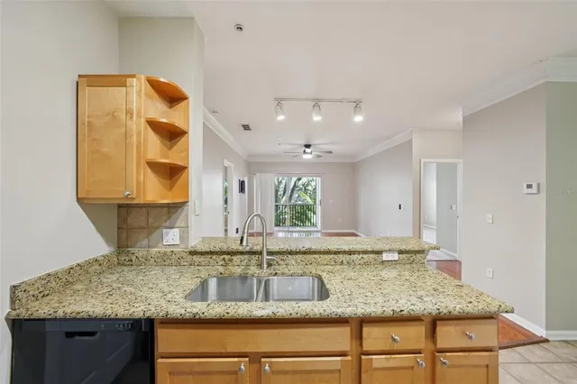 a kitchen with stainless steel appliances kitchen island granite countertop a refrigerator and a sink