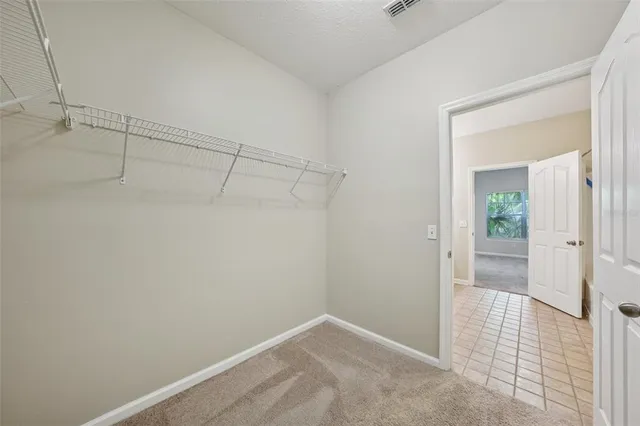 a view of an empty room with a chandelier fan
