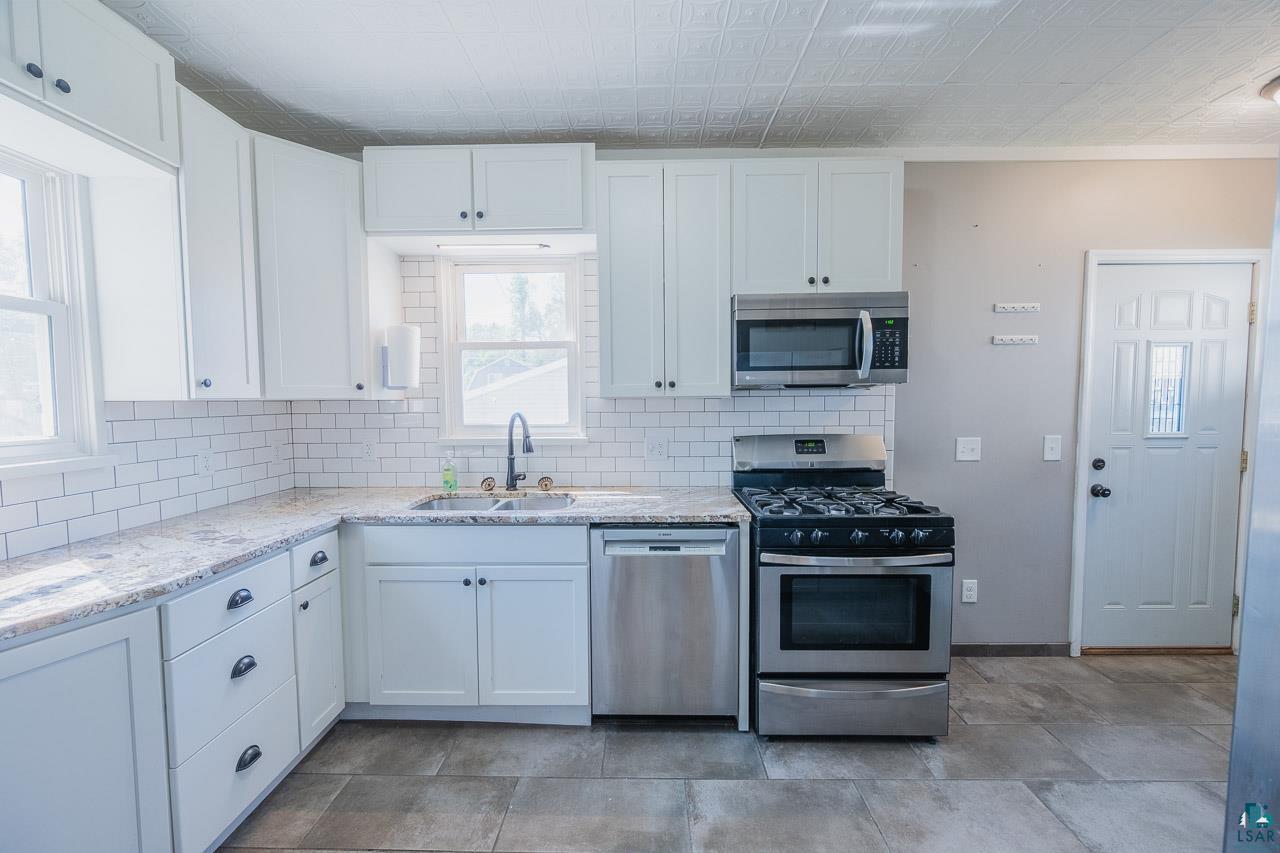508 10th Street South Virginia, MN 55792 - Photo 10 of 43 Modern kitchen featuring white shaker cabinetry and granite-look countertops
