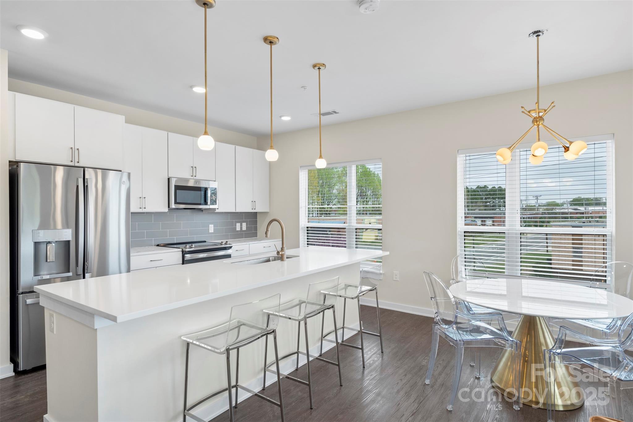 3630 North Davidson Street, Unit 3301 Charlotte, NC 28205 - Photo 3 of 33 a kitchen with stainless steel appliances granite countertop a stove a refrigerator a kitchen island a dining table and chairs