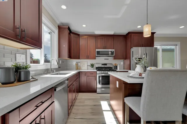 a kitchen with kitchen island granite countertop a sink counter space appliances and cabinets