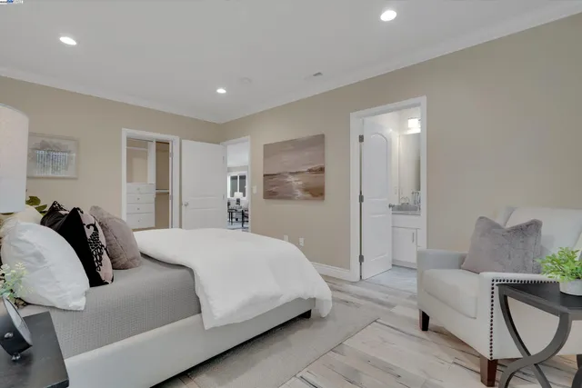 a spacious bedroom with a bed a couch and a view of kitchen