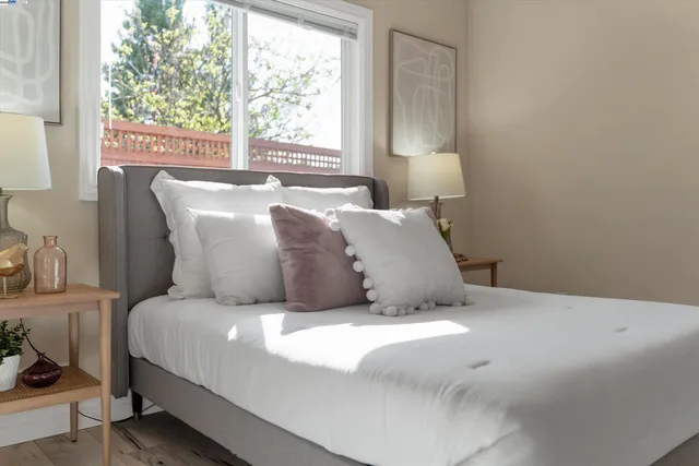 a large bed sitting in a bedroom next to a window