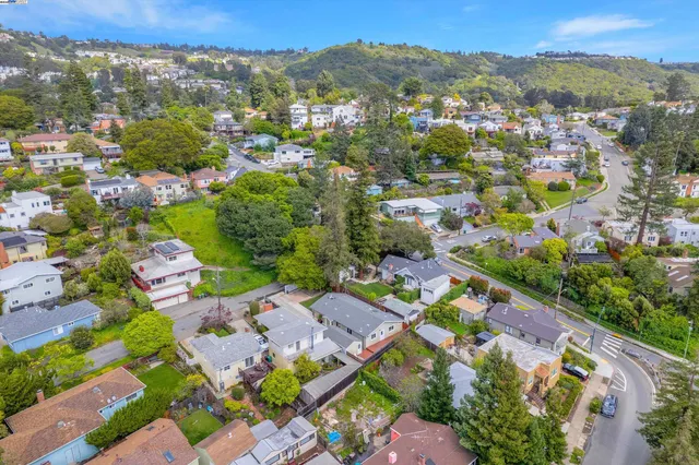 an aerial view of a house with a mountain