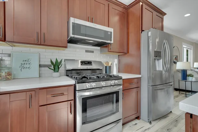 a kitchen with stainless steel appliances a stove microwave and refrigerator