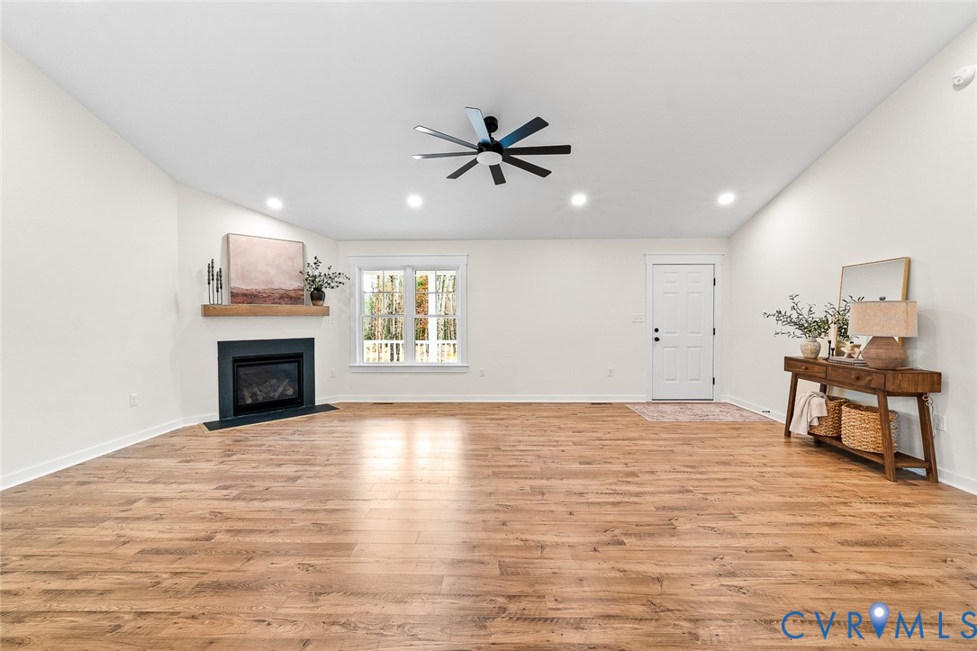 235 Bumpass Road Bumpass, VA 23024 - Photo 7 of 28 a view of a livingroom with a fireplace a ceiling fan and windows