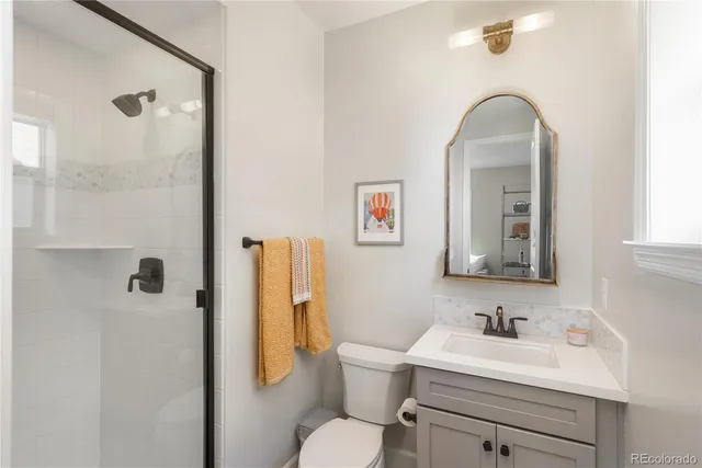 a bathroom with a toilet sink vanity and mirror