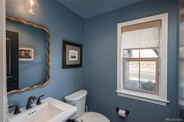 a bathroom with a sink mirror and toilet
