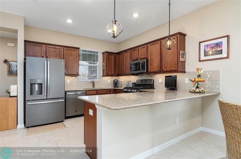 9857 Southwest 99th Loop Ocala, FL 34481 - Photo 12 of 45 a kitchen with stainless steel appliances granite countertop a refrigerator a sink dishwasher a stove and a refrigerator