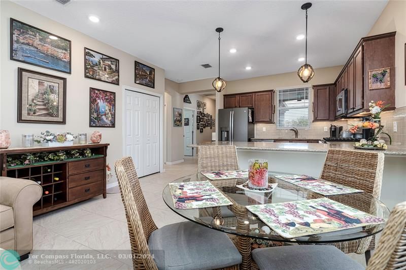 9857 Southwest 99th Loop Ocala, FL 34481 - Photo 15 of 45 a kitchen with stainless steel appliances kitchen island granite countertop a table chairs and a refrigerator
